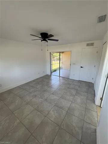 Unfurnished bedroom featuring a ceiling fan, access to outside, and light tile patterned floors