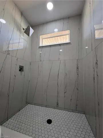 Full bathroom with a marble finish shower