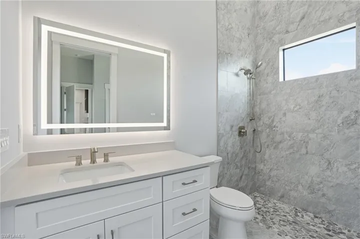 Full bath with a tile shower and vanity