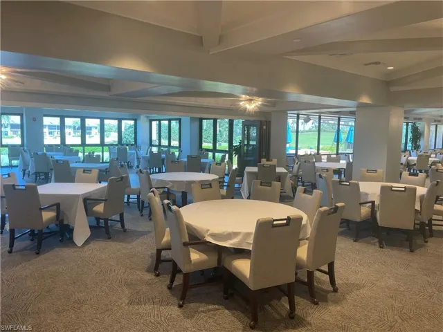 Carpeted dining room featuring healthy amount of natural light and beam ceiling