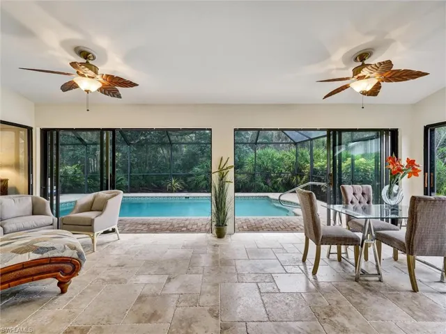 Outdoor pool featuring a ceiling fan and a sunroom
