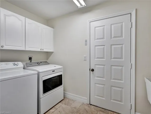 Laundry area featuring washing machine and clothes dryer and cabinet space