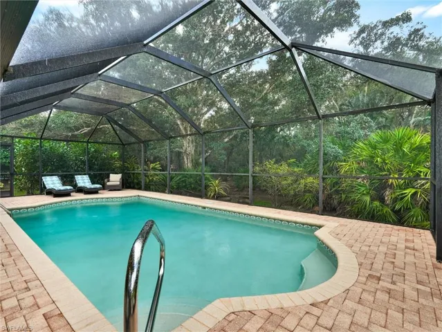 Swimming pool featuring a lanai, a sunroom, and a patio