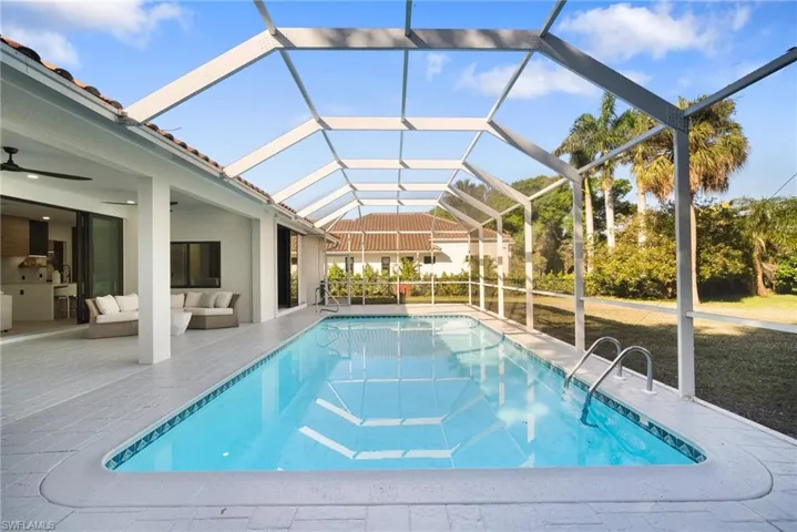 Outdoor pool featuring a sunroom, a patio area, a lanai, and outdoor lounge area