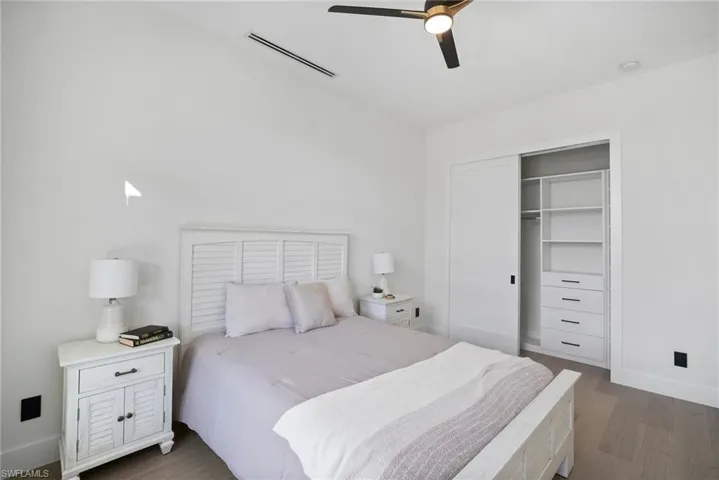 Bedroom featuring a closet, a ceiling fan, and dark wood-type flooring