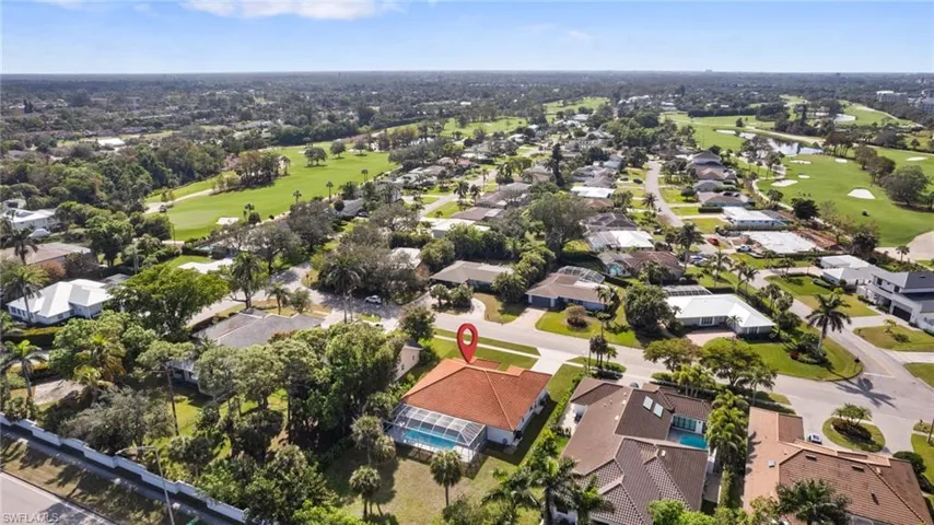 View of property location featuring a golf club, nearby suburban area, and a large body of water