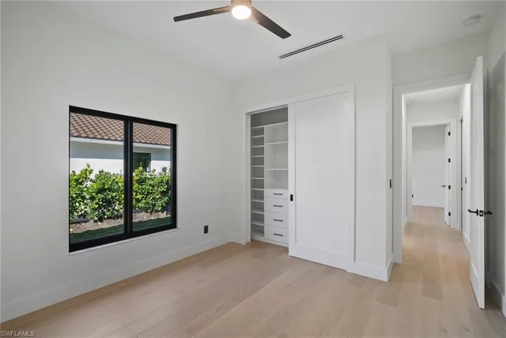 Unfurnished bedroom featuring light wood-style floors, a ceiling fan, and a closet
