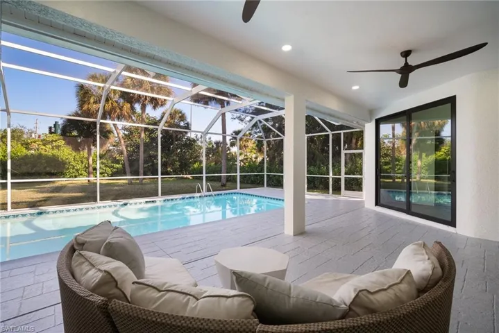 Swimming pool featuring a patio, a lanai, and a sunroom