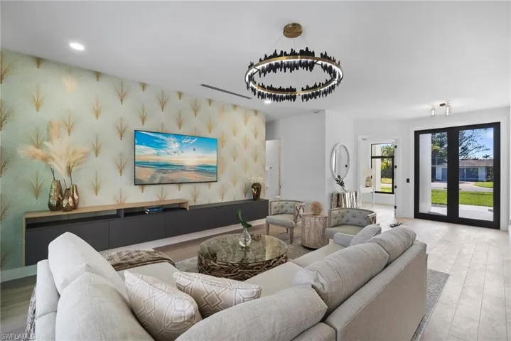 Living room featuring wallpapered walls, wood finished floors, recessed lighting, and an accent wall