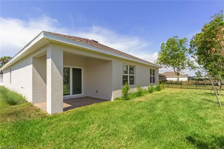 Rear view of house featuring stucco siding and a patio area