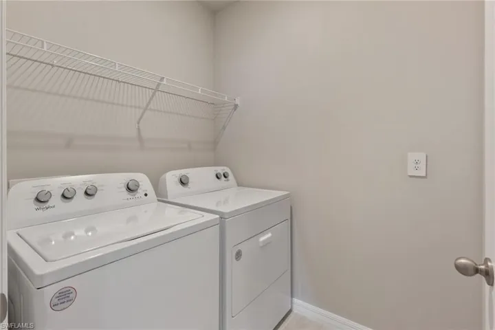 Washroom featuring washer and clothes dryer and baseboards