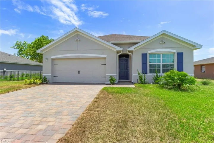 Single story home with stucco siding, decorative driveway, and a garage