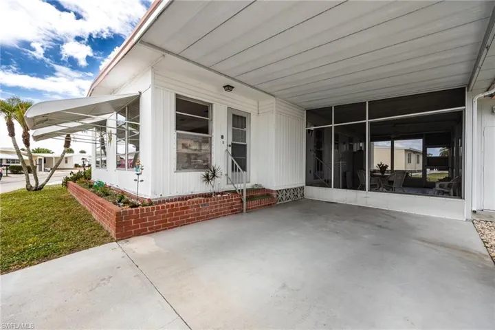 View of patio featuring an attached carport and a sunroom