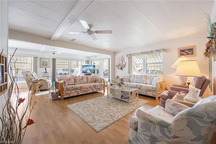 Living area featuring beamed ceiling and light wood-style flooring