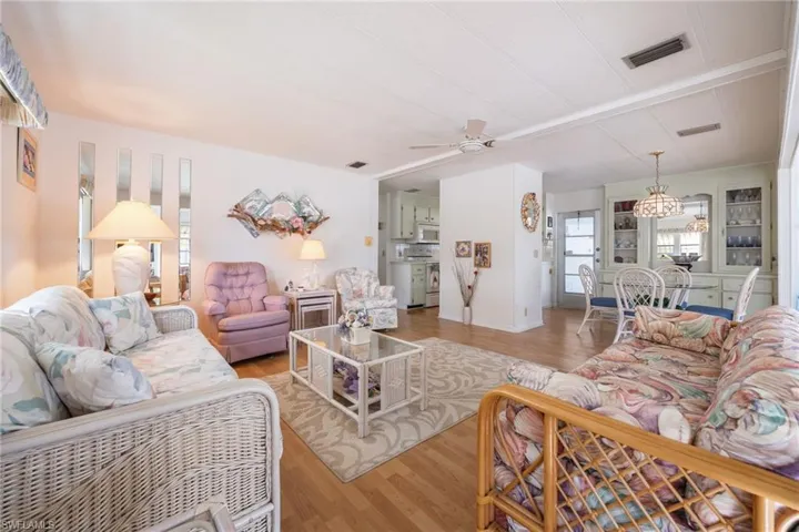 Living area featuring wood finished floors, ceiling fan, and a chandelier