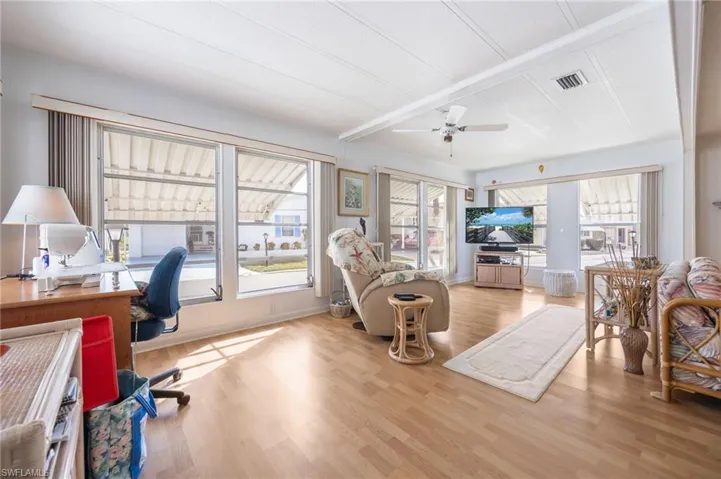 Office space with plenty of natural light, light wood finished floors, and ceiling fan