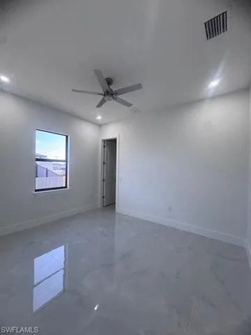 Spacious room featuring large format tile flooring, a contemporary ceiling fan, recessed lighting, and a window with a black frame