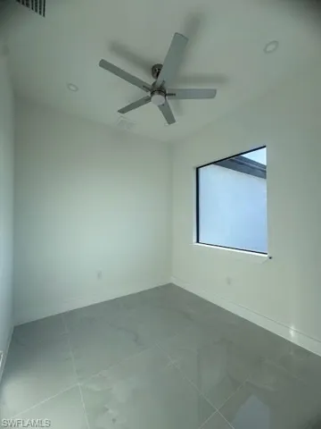 Room featuring a contemporary ceiling fan, recessed lighting, a single window, and large format tile flooring
