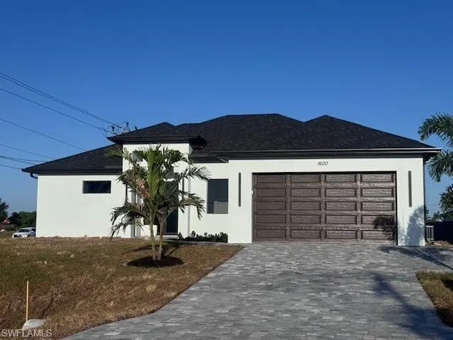 Contemporary stucco exterior with a dark shingle roof