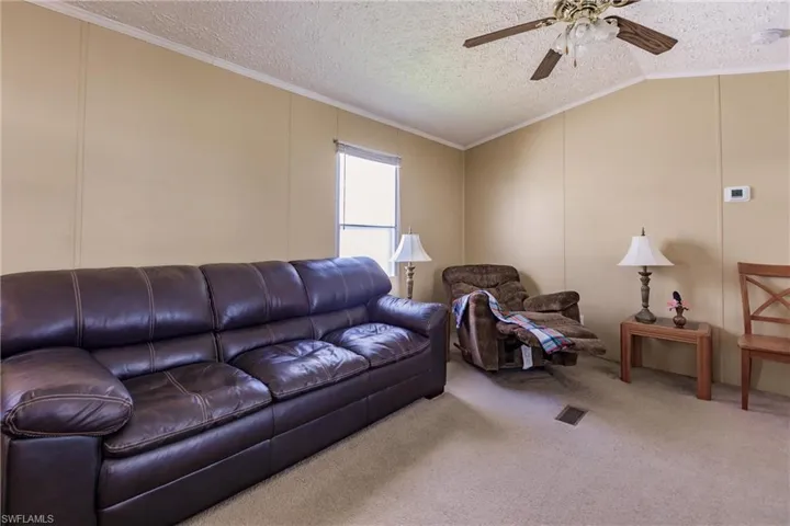 Living room with lofted ceiling and ceiling fan