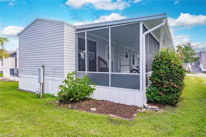Rear with a sunroom and a lawn