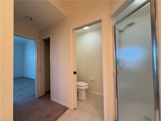 Bathroom featuring light carpet, a stall shower, and light tile patterned floors