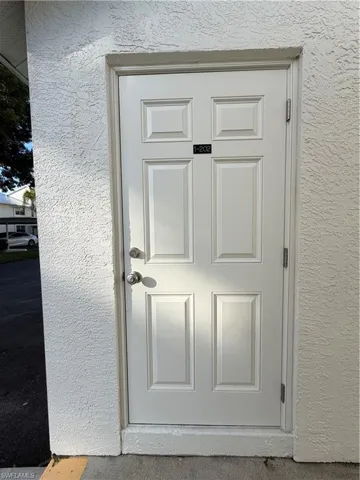 Doorway to property with stucco siding