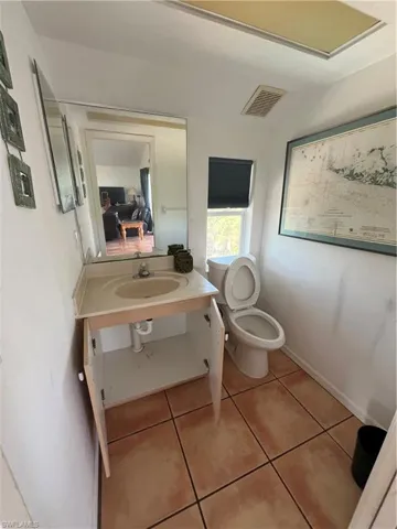 Bathroom featuring sink, tile flooring, and toilet