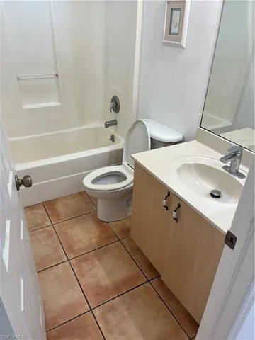 Full bathroom with shower / bathtub combination, tile flooring, vanity, and toilet
