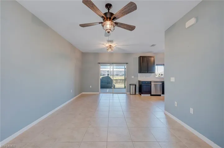 Unfurnished living room with a ceiling fan and light tile patterned floors
