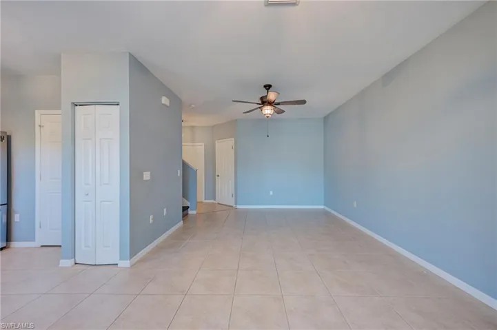 Empty room with a ceiling fan and light tile patterned floors