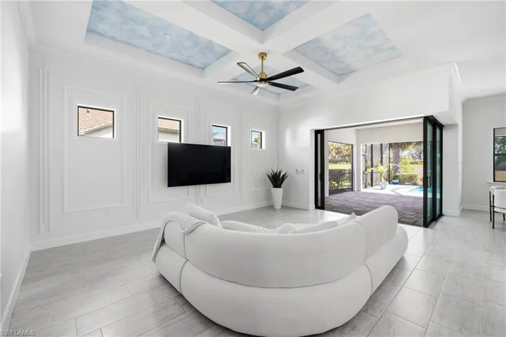 Open-concept living area with custom wood accent wall and new lighting