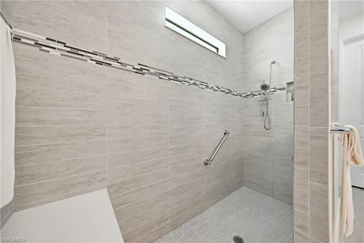Walk-in shower with clean tile finishes, glass enclosure, and a well-maintained, modern presentation.