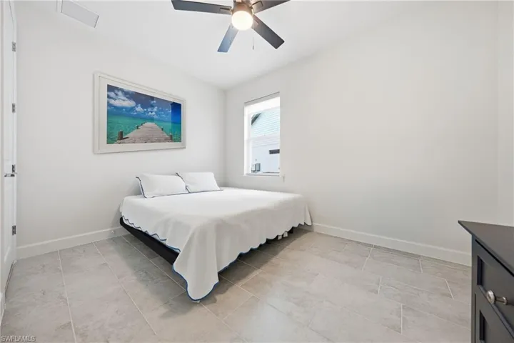 Guest bedroom with new tile flooring and updated lighting