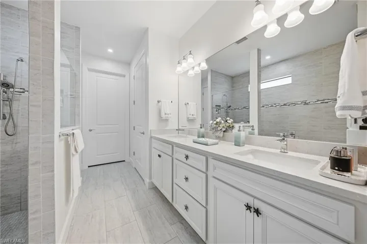Primary bathroom featuring dual vanities, fresh paint, updated lighting, and a clean, well-maintained layout designed for everyday comfort.
