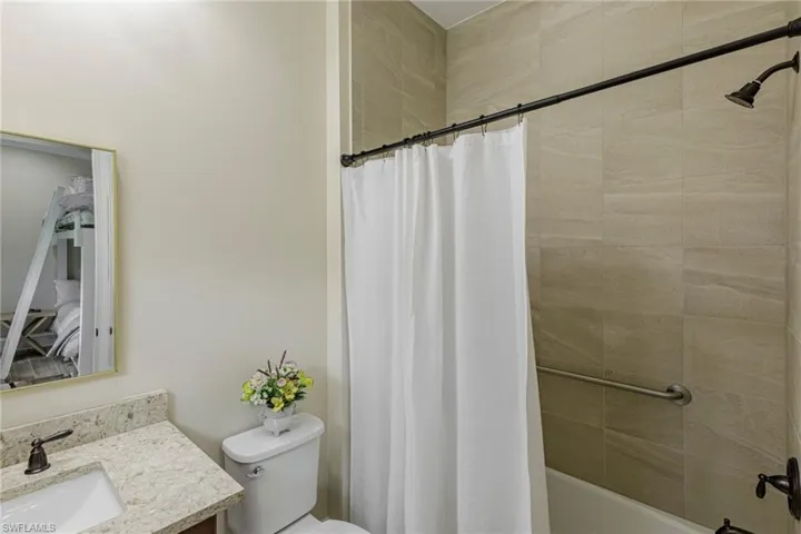 Full bathroom with shower / bath combo, toilet, and vanity