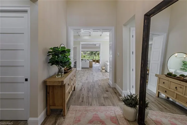 Hall featuring light wood-type flooring and a high ceiling