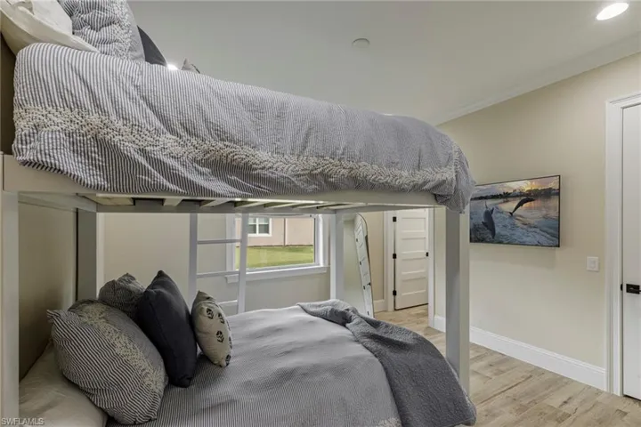 Bedroom with light hardwood / wood-style floors and ornamental molding