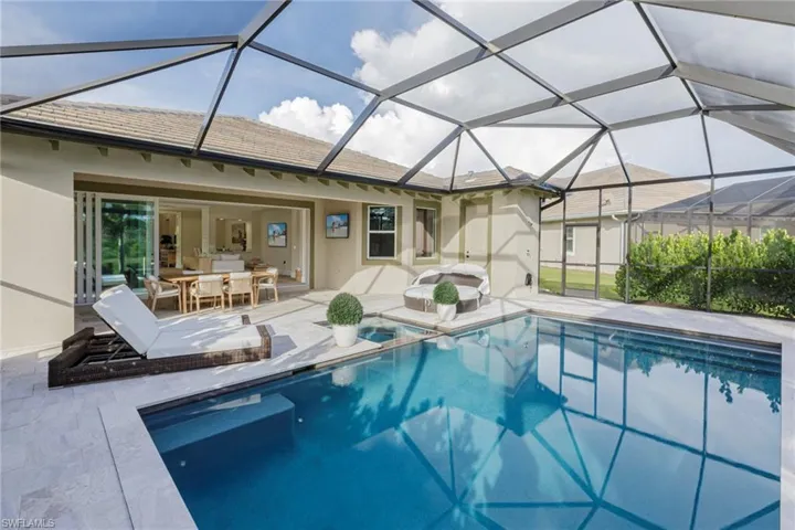 View of pool featuring a patio and glass enclosure