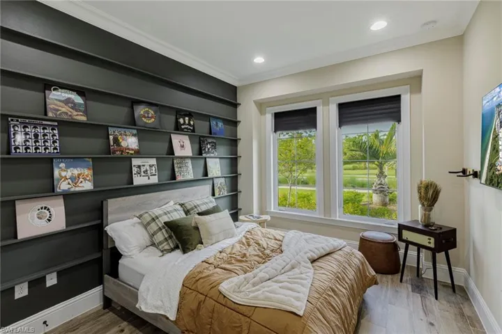 Bedroom with wood-type flooring and ornamental molding