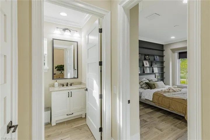 Bathroom with vanity, crown molding, and hardwood / wood-style floors