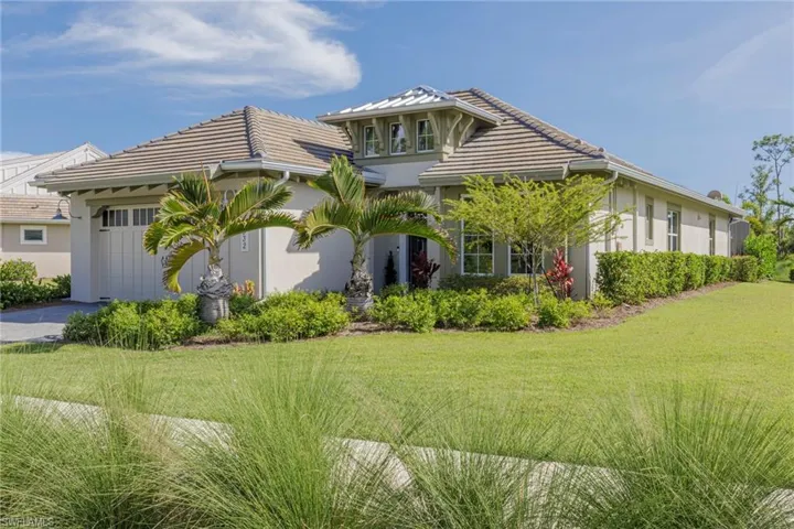 View of front of home with a garage and a front lawn
