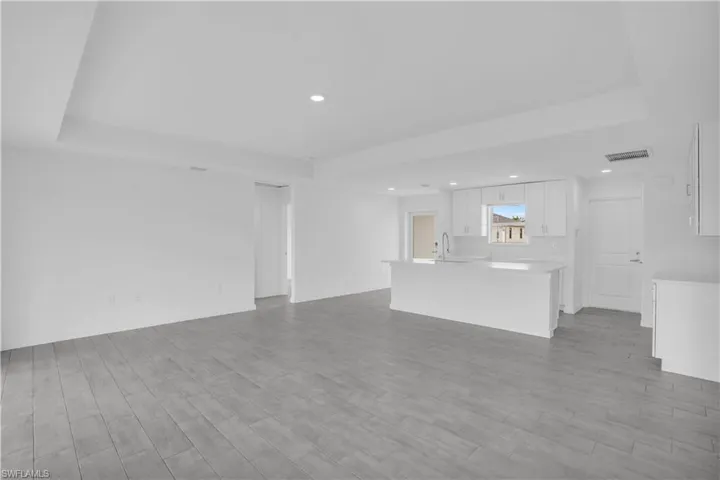 Open-concept living area featuring wood-finish tile flooring and recessed lighting