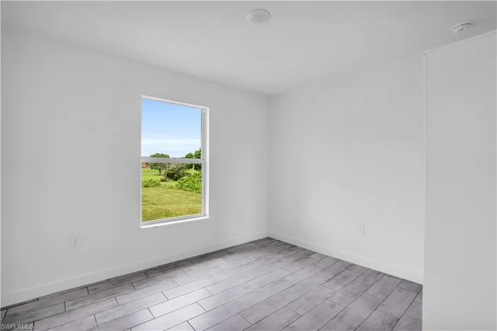 Bright room featuring a single window, offering an outdoor landscape
