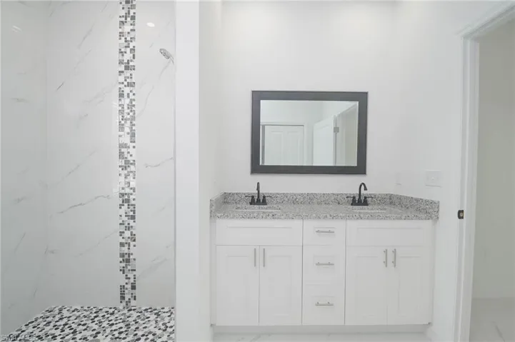 Bathroom featuring vanity and a tile shower