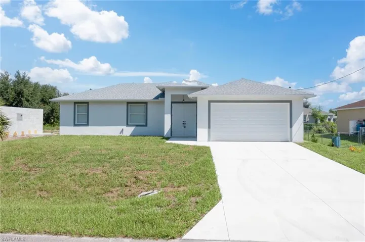 View of front of home featuring a front yard and a garage