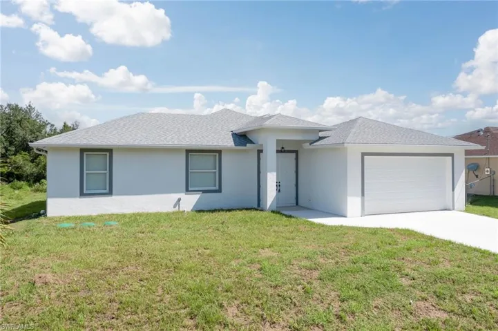 View of front facade featuring a garage and a front yard