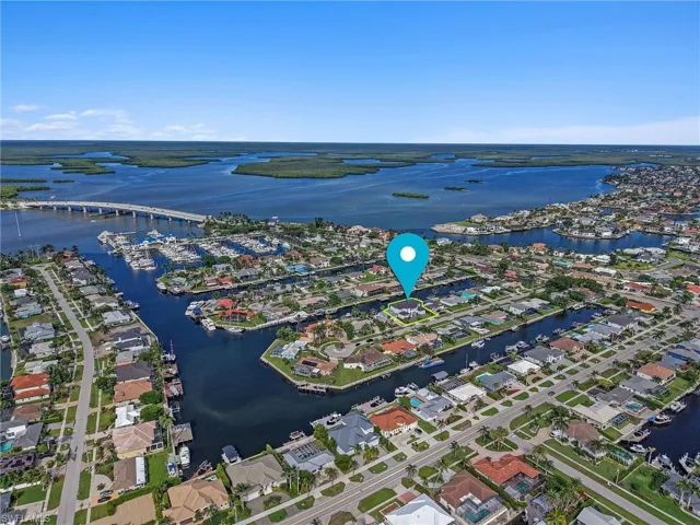 Aerial drone view high above Marco Island highlighting the Collier Bridge entrance and pinpointing the location of this luxury waterfront property.