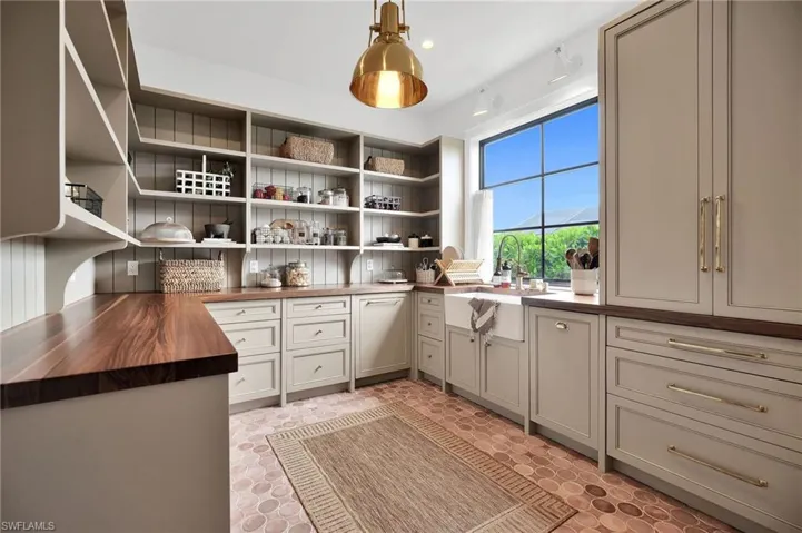 Scullery with white oak cabinetry, open shelving, coffee station space, and Brizo fixtures—also serves as auxiliary laundry