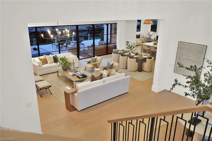 From the foyer, sightlines extend to the conversation zone with shellstone fireplace and the upper-level foyer above.